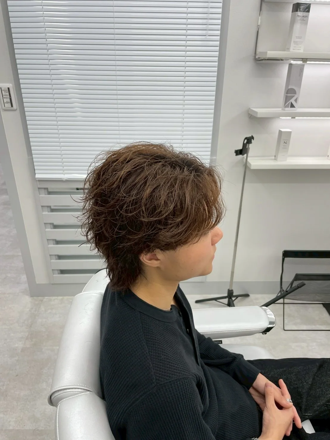 施術後のヘアスタイルを確認しているお客様
