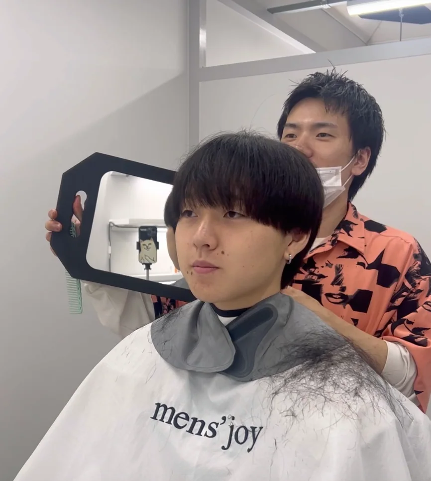 小坂尚輝さんがお客様の仕上がりを鏡で確認している様子